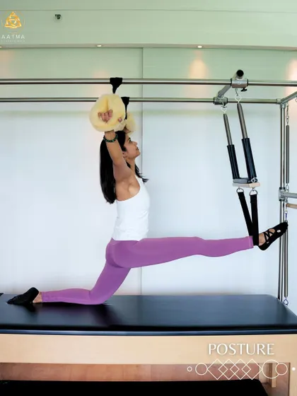A beautiful split stretch on the Cadillac. This advanced move showcases the incredible flexibility and control that can be achieved with consistent Pilates practice.