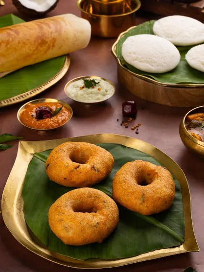 A close-up on the crispy medu vadas from the South Indian spread, highlighting their golden-brown texture.