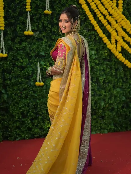 A beautiful shot against a backdrop of marigolds. The bride's makeup is kept fresh and radiant, complementing the festive and colorful wedding decor.