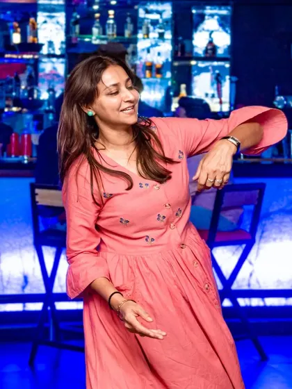 A guest dancing freely, enjoying the music and the atmosphere. The pink dress adds a pop of color to the scene.