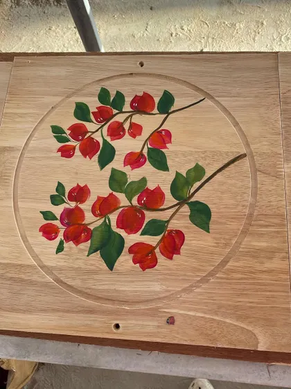 Bright red bougainvillea flowers painted on a wooden board. The natural grain of the wood provides a beautiful, rustic background for the artwork.