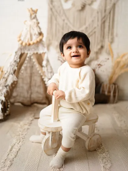 That happy, curious smile is what milestone sessions are for. I designed this neutral-toned boho setup to let this little one's bright personality shine through as he explores his world.