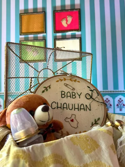 A detailed shot of the hand-embroidered welcome sign for the baby, a cherished keepsake from the special day.