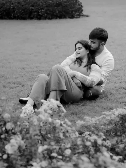 A quiet, peaceful moment captured in black and white. This image from a pre-wedding shoot focuses on the serene comfort the couple finds in each other's arms, away from the chaos.