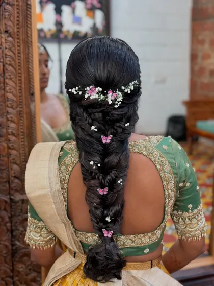 The reflection in the mirror adds depth to this beautiful butterfly-themed braid. The combination of flowers and butterflies creates a truly magical look.