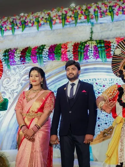 The couple poses with Yakshagana artists at their reception, a unique and beautiful way to incorporate local culture into their celebration.