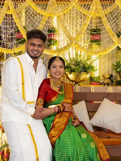 The happy couple at their traditional South Indian baby shower. The decor is rich with cultural elements, creating a perfect setting for their celebration.