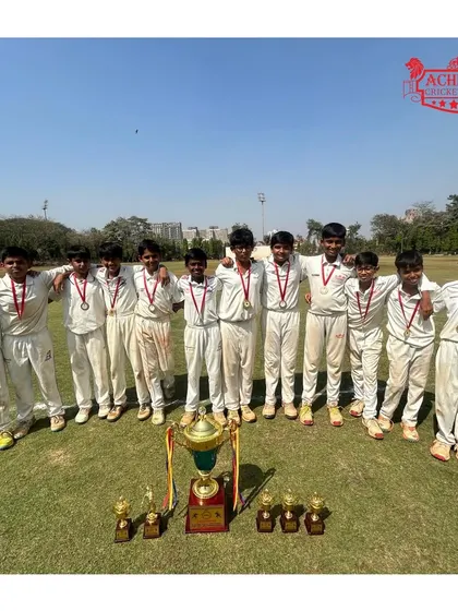 The U-12 boys' team celebrating their championship win at the ASMC U-12 tournament, showcasing their medals and the grand trophy.