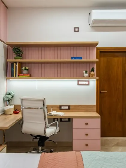 A close-up of the built-in study desk, showing the pink tiled backsplash and open shelves for books and decor. The design is both practical and aesthetically pleasing, perfect for a young student.