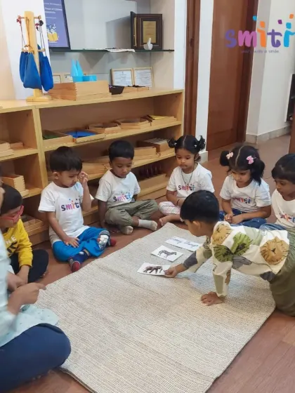A child crawls forward to place an animal card during a group lesson. We encourage active participation and movement to keep learning dynamic and engaging.