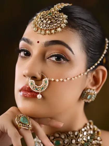 A close-up on a North Indian bridal look, focusing on the winged eyeliner, maang tikka, and nath. This is a key look taught in our pro course.