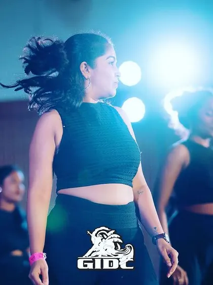 An artistic shot capturing the movement and emotion of a dancer mid-performance at GIDC, with the stage lights creating a dramatic effect.