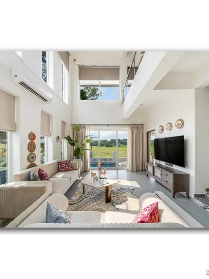 This view of the living room at Casa D Umravi looks out onto the pool and verdant fields beyond. The high ceilings and large glass doors blur the line between indoors and out, creating a perfect holiday atmosphere.