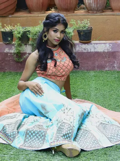 I love playing with contrasting colors and prints. This fusion lehenga set pairs a peach-colored embroidered crop top with a sky-blue skirt that features beautiful bird and architectural motifs.