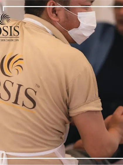 Our team is easily identifiable in their Iosis uniforms, ready to provide a moment of relaxation at any event. Here, a therapist is seen during a busy on-site wellness session.