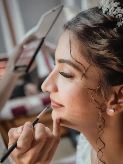 The final touches. A close-up on the lip application, showing the detail and precision that goes into creating the perfect bridal look.