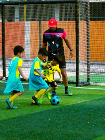 A coach observes a small-sided game with our youngest players, ensuring they learn the rules and play fairly.