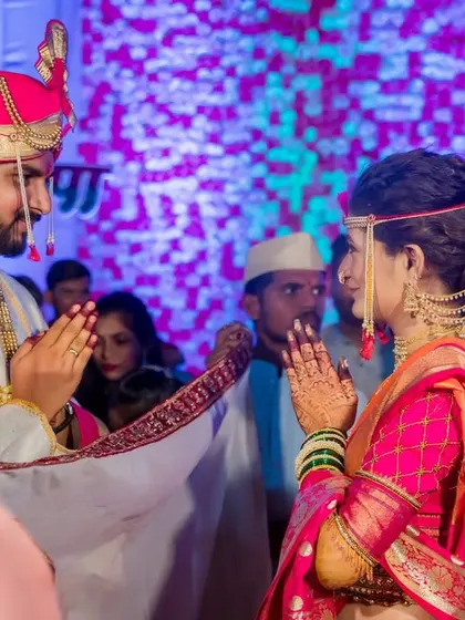 The bride and groom stand opposite each other during the antarpat ritual, a moment of anticipation before they see each other.