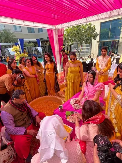 The Haldi ceremony in full swing. This photo shows the vibrant setup and the bride surrounded by family, ready for the rituals.