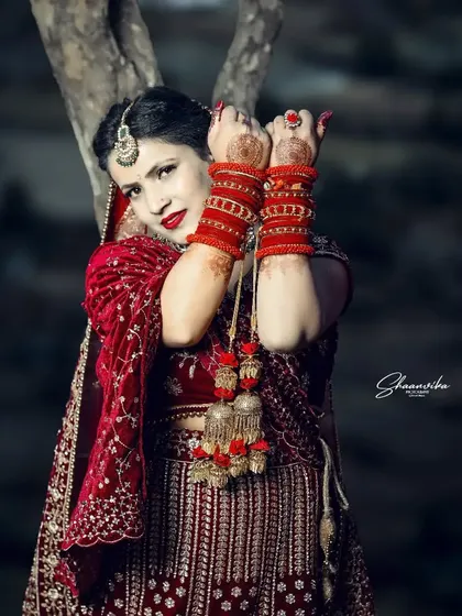 A powerful and confident pose from the bride, showcasing her beautiful red bangles and kalire. This portrait captures the strength and beauty of a modern bride.