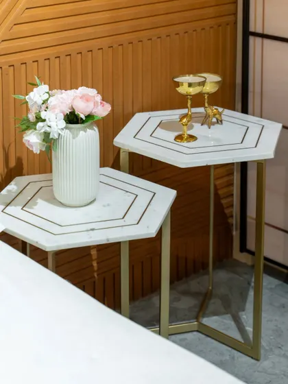 A pair of nesting hexagonal side tables with a marble top and gold inlay. This offers flexible surface space and adds a geometric, art-deco flair to the bedroom.