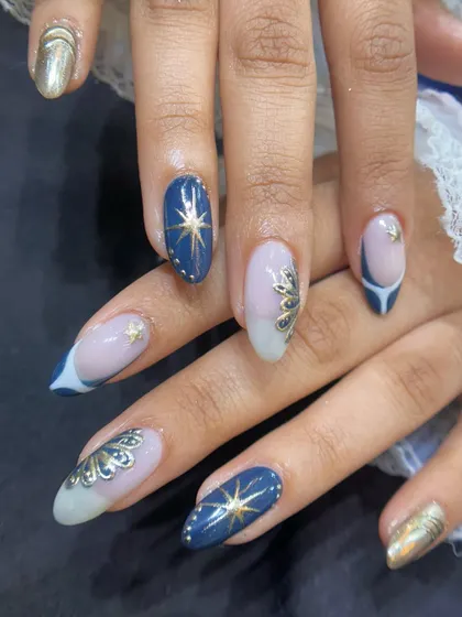 Another angle of the celestial-themed nail art. You can see the detail in the golden accents and how the combination of navy blue, sheer nude, and chrome gold creates a balanced and stunning look.