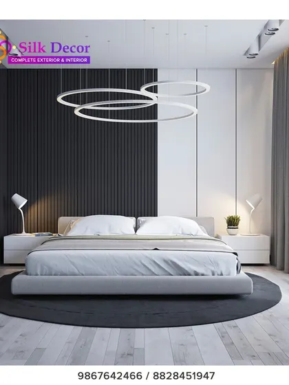 For clients who prefer a minimalist aesthetic, we design clean and contemporary pieces. This bedroom features one of our low-profile upholstered beds in a simple grey fabric, set against a striking black and white accent wall. The modern ring pendant lights complete the sleek, uncluttered look.