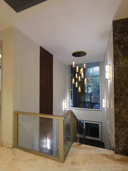 This staircase is more than just functional; a grand chandelier adds glamour to every step, while marble and wood textures create a sense of timeless luxury.