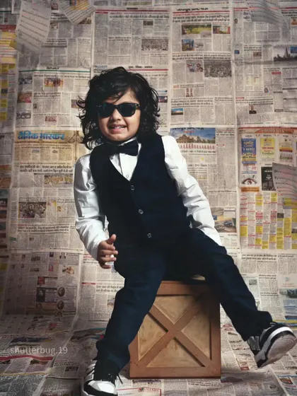 This little star is slaying in his sunglasses, looking like a true model in our newspaper backdrop shoot.