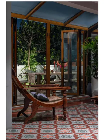 A quiet corner in the Dhaka home at night. The lighting transforms the space, highlighting the texture of the patterned floor and the elegant lines of the chair sourced from Cochin. It shows how a space can have different moods throughout the day.