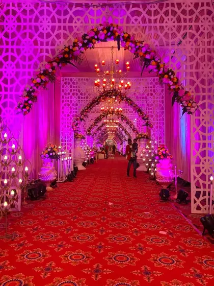 A slightly different angle of the grand purple entrance, highlighting the candle-like light installations and floral arrangements that line the path.