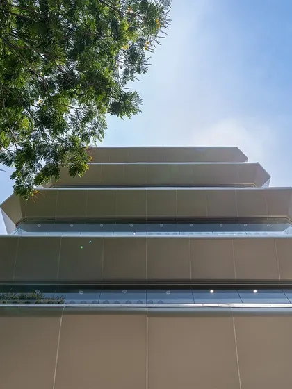 A worm's-eye view of the stacked overhangs on the Nalli facade. This functional element is designed to manage wind, rain, and sun while creating a strong visual identity.