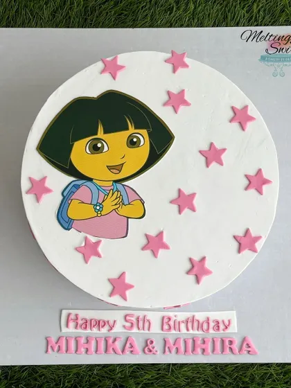 A top-down view of the Dora the Explorer cake, showing the clean design and precise placement of the edible art and fondant stars.