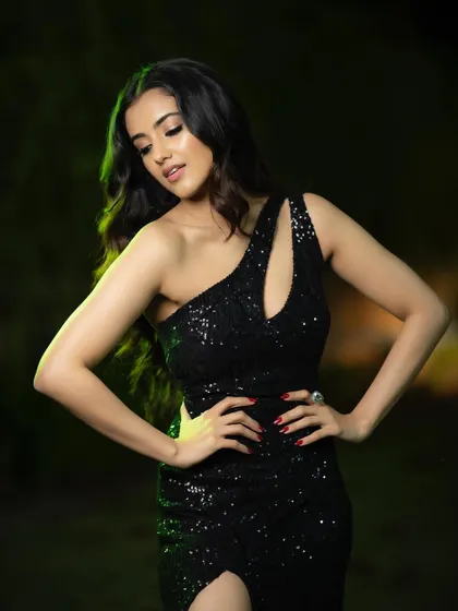 This pose emphasizes the cut and fit of the dress. The lighting is designed to catch the sparkle of the sequins while sculpting the pose, resulting in a striking and fashionable portrait.