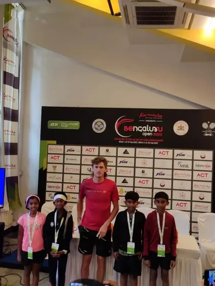 Our junior players standing with a professional athlete at the Bengaluru Open. These interactions are invaluable for inspiring the next generation of tennis stars.