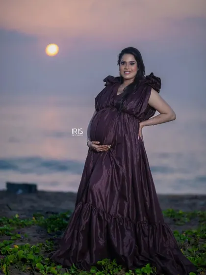 A stunning sunset shot from a beach maternity session. The brown taffeta gown's silhouette looks incredible against the evening sky.