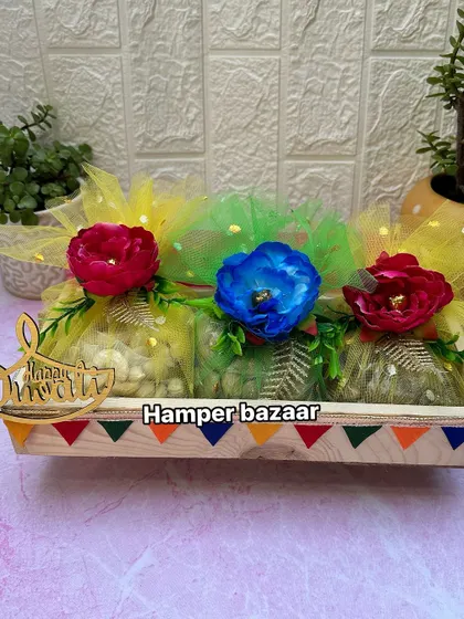 Another one of our budget-friendly dry fruit trays for Diwali. Here, the dry fruits are packed in colorful potlis and arranged in a decorated pine wood tray for a festive look.