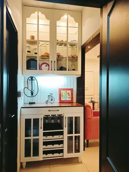A beautiful white hutch cabinet with arched glass doors and an integrated wine rack. This piece is perfect for a dining area, providing storage for crockery, glassware, and wine bottles.