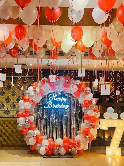 Another view of the 75th birthday decoration, showing the full setup with marquee numbers and a neon sign.