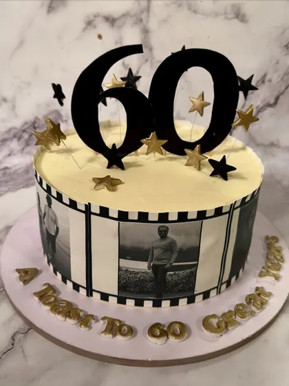 A journey through time for a 60th birthday. This cake features an edible photo filmstrip with pictures from the client's life, making it a truly personal and nostalgic centerpiece.