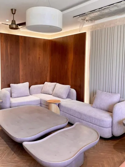 This living area showcases our organic and earthy design style. The custom sectional sofa in a textured lilac bouclé fabric and our curvy, micro-topped concrete tables create a warm, inviting, and cohesive look.