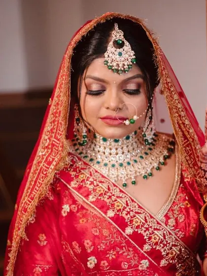 Our prettiest bride stealing hearts in a classic red lehenga. This look features a soft smokey eye with a hint of green to match her jewelry, showcasing the importance of a cohesive, detailed approach.