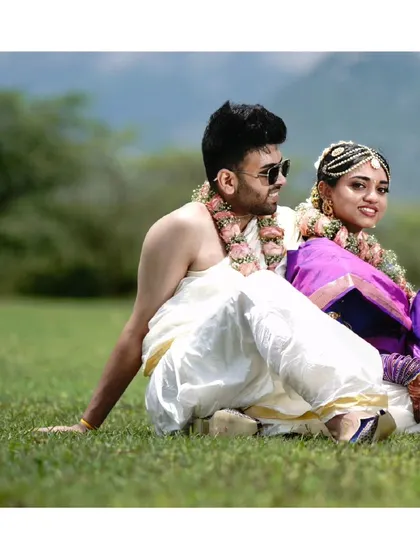 A candid, joyful moment from a traditional South Indian post-wedding shoot. The natural setting and relaxed pose make this a beautiful memory of their new beginning.