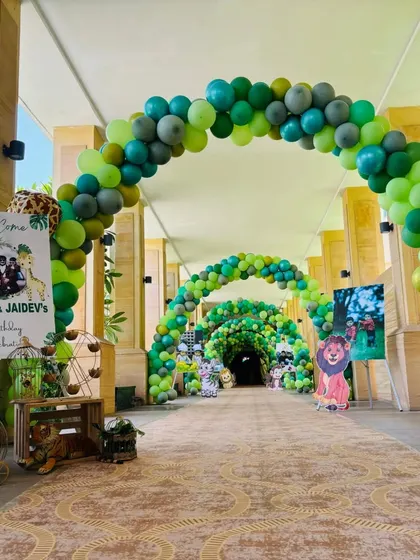 A stunning jungle-themed entrance tunnel made entirely of green balloons, creating an immersive experience for guests.