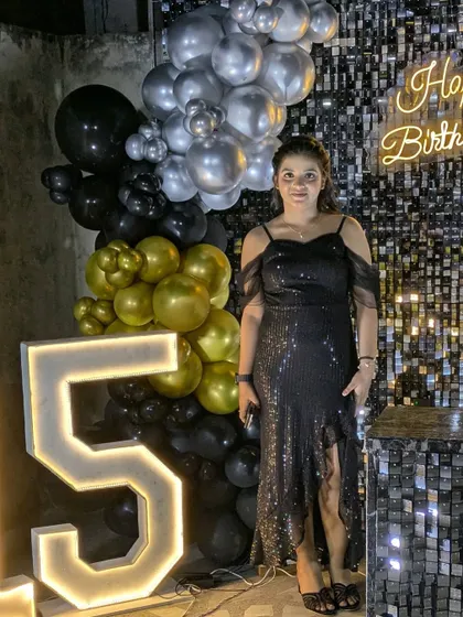 The combination of chrome balloons and a sequin wall creates a sophisticated look for milestone birthdays.