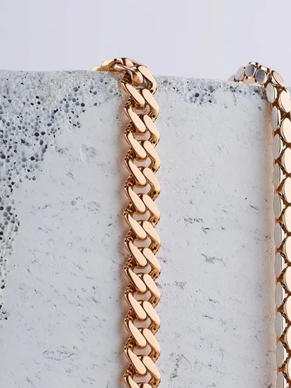 Gold chains and concrete blocks. A study in contrasts. This minimalist shot for Mohini focuses on the texture and form of the gold chains against a rough, industrial-style block.