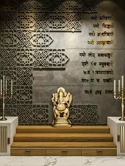 I designed this pooja room to be a tranquil and modern sacred space. The design features intricate jaali work on a concrete-finish wall, with elegant gold lettering of the Navkar mantra and a Ganesha idol on a raised wooden platform, creating a peaceful corner for prayer.