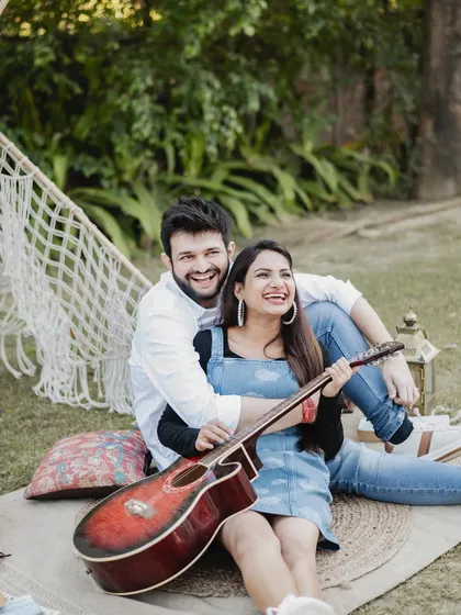 A fun, candid moment during a picnic-themed shoot. Using props like a guitar allows the couple's personality to shine through, resulting in photos that are both beautiful and uniquely them.