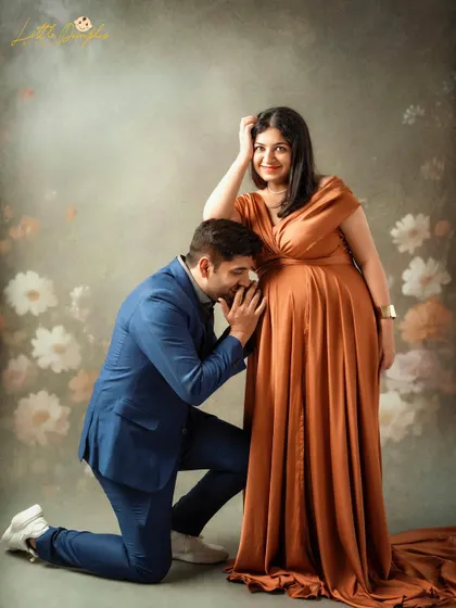 A sweet and classic pose with the dad-to-be kissing the baby bump. The floral background adds a touch of romance to this studio portrait.