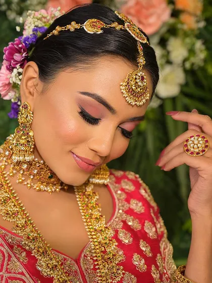 We are obsessed with this look. The pop of pink on the eyes and lips adds a fresh, modern touch to the traditional gold jewelry and silk saree.